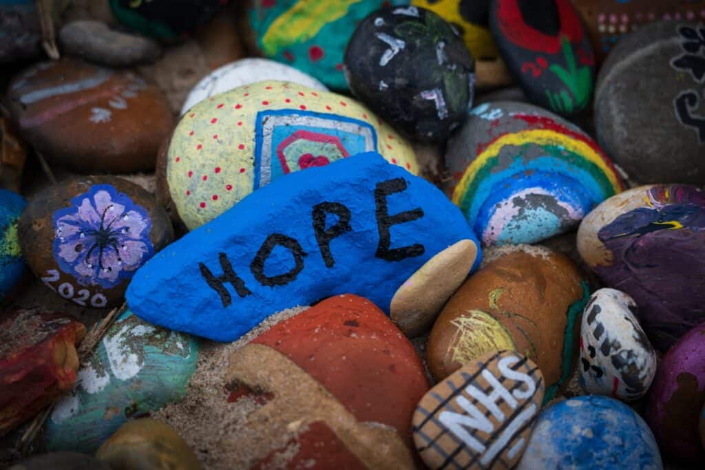 A blue stone among other colorful stones with the word hope on it showing there is good reason to remain hopeful in relapse prevention and addiction recovery from dependency. 