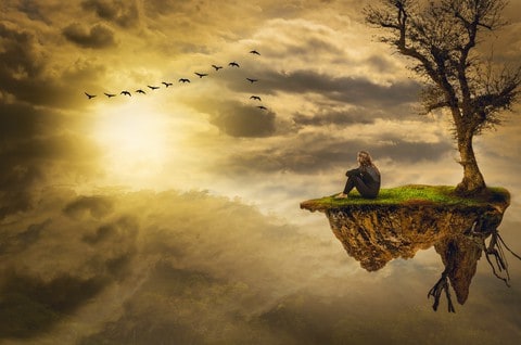 A cloudy sky with birds flying in formation on the top left, and the sun shining through below the birds.  On the right side of the picture a small piece of land with a naked tree, grass, and visible tree roots. A person sitting alone in front of the tree.  Feeling depressed can make people feel lonely and alone in the world. 