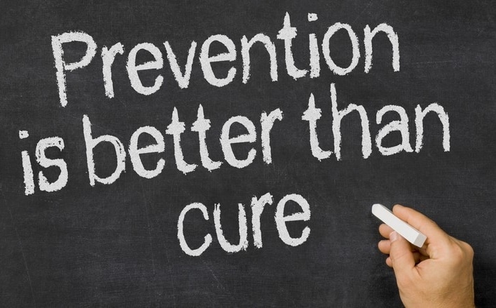 A dark grey chalk board with 3 rows of words written in white chalk and cantered in the middle.  First row the word prevention, second row the words is better than, the third row the word cure.