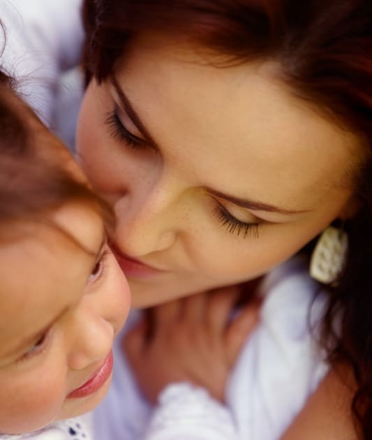 Good parents. Mother and child.  Parent, parenting and parenthood. The picture shows the faces of a mother hugging a child. 