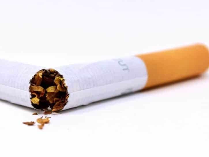 Quitting smoking with hypnosis. A filter cigarette broken in half on white background.  This shows that smokers can quit smoking