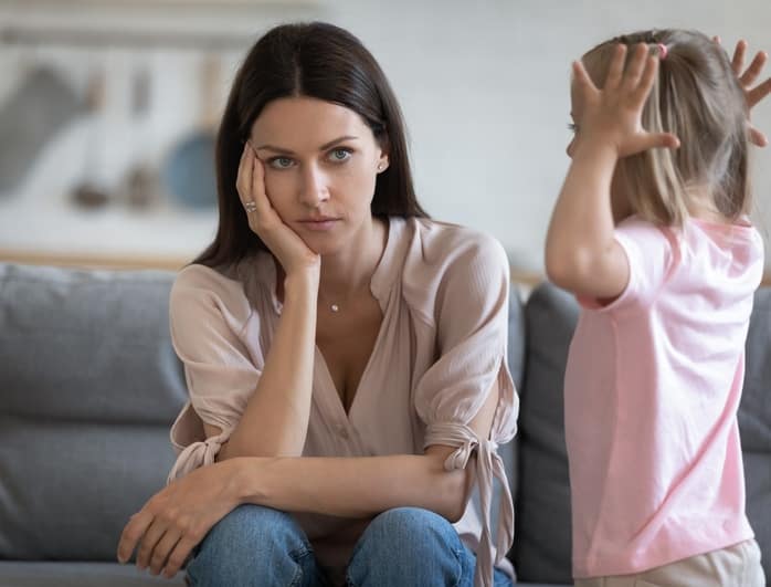 ADHD in children. The picture shows a scene with overwhelmed mother and a hyperactive child 